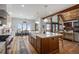Open kitchen with large island and breakfast bar overlooking snowy landscape at 4075 Merada Ct, Franktown, CO 80116