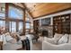 Spacious living room with stone fireplace, built-ins, and vaulted ceiling at 4075 Merada Ct, Franktown, CO 80116