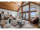 Bright, open living room featuring wood ceiling, large windows, hardwood floors, and stylish furniture at 4075 Merada Ct, Franktown, CO 80116