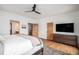 Well-lit main bedroom with hardwood floors, featuring a ceiling fan and an attached ensuite bathroom at 4075 Merada Ct, Franktown, CO 80116