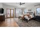 Serene main bedroom with natural light, hardwood floors, balcony access, and cozy seating bench at 4075 Merada Ct, Franktown, CO 80116
