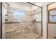 Elegant tiled shower with glass surround, bench seating, and dual shower heads provides a luxurious bathing experience at 4075 Merada Ct, Franktown, CO 80116