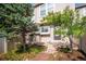 Back of the house with a small backyard with green grass and pine trees at 9621 W Chatfield Ave # F, Littleton, CO 80128