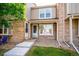 Inviting front entrance with brick facade, covered porch, and well-manicured landscaping at 9621 W Chatfield Ave # F, Littleton, CO 80128