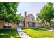 Charming townhome featuring a well-maintained lawn, brick accents, and a welcoming entrance at 9621 W Chatfield Ave # F, Littleton, CO 80128