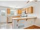 Well-lit kitchen featuring wood cabinets, stainless steel appliances, and breakfast bar at 9621 W Chatfield Ave # F, Littleton, CO 80128