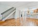 Open-concept living space with hardwood floors, staircase, and breakfast bar to the kitchen at 9621 W Chatfield Ave # F, Littleton, CO 80128
