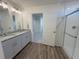 Bright bathroom with dual sinks, granite counters, walk-in shower, and access to the bedroom at 22023 E 38Th Pl, Aurora, CO 80019