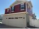 Attractive home with a two-car garage, red siding, gray stucco, and well-maintained landscaping at 22023 E 38Th Pl, Aurora, CO 80019