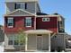 Two-story home showcasing red siding, gray stucco, dark shutters, and a cozy covered entry at 22023 E 38Th Pl, Aurora, CO 80019