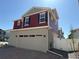 Stylish home featuring a two-car garage, red siding, gray stucco, and crisp white trim at 22023 E 38Th Pl, Aurora, CO 80019