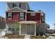 Two-story home showcasing red siding, gray stucco, dark shutters, and a cozy covered entry at 22023 E 38Th Pl, Aurora, CO 80019