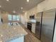 Bright, modern kitchen featuring white cabinets, stainless steel appliances, and a granite island at 22023 E 38Th Pl, Aurora, CO 80019
