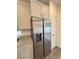 Close up of kitchen features stainless steel refrigerator and sleek white cabinets for ample storage at 22023 E 38Th Pl, Aurora, CO 80019