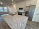 Bright kitchen with a large granite island, stainless steel appliances, and ample cabinet space at 22023 E 38Th Pl, Aurora, CO 80019