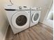 Modern washer and dryer in a bright laundry room with wood-look floors at 22023 E 38Th Pl, Aurora, CO 80019