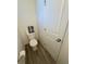 Cozy powder room featuring toilet, wood-look floors, and decorative towels at 22023 E 38Th Pl, Aurora, CO 80019