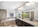 Primary bathroom with dual sinks, granite countertops, a soaking tub, and a glass-enclosed shower at 5929 Echo Hollow St, Castle Rock, CO 80104