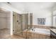 Luxurious bathroom with a glass shower, soaking tub, and stylish wood-look tile accents at 5929 Echo Hollow St, Castle Rock, CO 80104