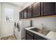 Functional laundry room with a sink, counter space, and overhead cabinets for storage at 5929 Echo Hollow St, Castle Rock, CO 80104