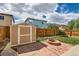 Landscaped backyard featuring a shed, fire pit, and seating area, framed by a wooden fence at 4081 Odessa St, Denver, CO 80249