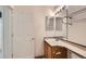 Bathroom with a vanity featuring a sink, mirror, and a towel rack beside a white door at 4081 Odessa St, Denver, CO 80249