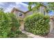 View of the side of the home showing lush greenery and the two-car garage at 4081 Odessa St, Denver, CO 80249