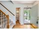 Bright foyer featuring wood floors, staircase with carpet, and a view of the powder room at 4081 Odessa St, Denver, CO 80249