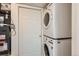 Efficient laundry area with stacked washer and dryer next to the door and utility infrastructure at 4081 Odessa St, Denver, CO 80249