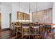 Entertaining bar area with wood cabinets, custom granite countertop, wooden chairs, and pool table in background at 8278 Raphael Ln, Littleton, CO 80125
