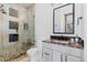 Modern bathroom features a glass shower with unique stone tile and stylish vanity with granite counters at 8278 Raphael Ln, Littleton, CO 80125