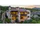 Sunset view of multi-story home with multiple patios, stone accents, and manicured landscaping at 8278 Raphael Ln, Littleton, CO 80125