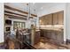 Kitchen/Living room featuring custom wood cabinets, stone counter tops, modern lighting, and rustic wood beams at 8278 Raphael Ln, Littleton, CO 80125