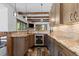 Kitchen featuring custom wood cabinets, granite counter tops, tiled back splash, and rustic wood beams at 8278 Raphael Ln, Littleton, CO 80125