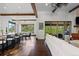 Bright, open-concept living room with wood beam ceilings, floor-to-ceiling windows, and hardwood flooring at 8278 Raphael Ln, Littleton, CO 80125