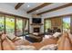 This living room includes exposed beams, stone fireplace, and private patio access at 8278 Raphael Ln, Littleton, CO 80125