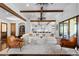 Open-concept living space with wood beams, comfortable seating, access to the kitchen, and outdoor patio at 8278 Raphael Ln, Littleton, CO 80125