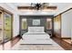 This main bedroom boasts exposed wood beams, modern finishes, and private balcony access at 8278 Raphael Ln, Littleton, CO 80125