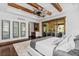 The main bedroom offers exposed wood beams, patio access, and an elegant entertainment bar at 8278 Raphael Ln, Littleton, CO 80125