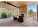 Inviting covered patio has a stone fireplace, wood ceiling, and views of the scenic mountains at 8278 Raphael Ln, Littleton, CO 80125