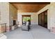 Covered patio boasts a cozy fireplace, wood ceiling, stone columns, and picturesque hillside view at 8278 Raphael Ln, Littleton, CO 80125