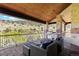 Covered outdoor living space with wood ceiling, stone columns, outdoor kitchen, and hillside views at 8278 Raphael Ln, Littleton, CO 80125