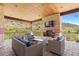Covered patio with stone fireplace and comfortable seating; perfect for outdoor entertaining at 8278 Raphael Ln, Littleton, CO 80125