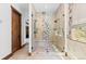 This tiled shower includes stone accents, bench seating, and bright light at 8278 Raphael Ln, Littleton, CO 80125