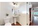 This bathroom features a pedestal sink, hardwood floors, and a decorative mirror and lighting fixture at 10109 Yampa St, Commerce City, CO 80022