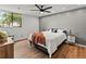 Comfortable bedroom featuring hardwood floors, a shiplap accent wall, and a large window with natural light at 3001 S Ursula Cir # 101, Aurora, CO 80014