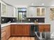 Bright kitchen featuring modern appliances, two-tone cabinets, dark backsplash, and a large window for natural light at 3001 S Ursula Cir # 101, Aurora, CO 80014