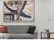 Cozy living room featuring a gray sofa, minimalist decor, and a large abstract art piece on the wall at 3001 S Ursula Cir # 101, Aurora, CO 80014