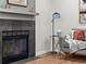 Living room showcasing a fireplace, gray sofa, sleek floor lamp, and hardwood floors for a cozy and modern space at 3001 S Ursula Cir # 101, Aurora, CO 80014