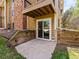 Ground level patio with sliding glass doors and wood retaining walls for garden bed at 3001 S Ursula Cir # 101, Aurora, CO 80014
